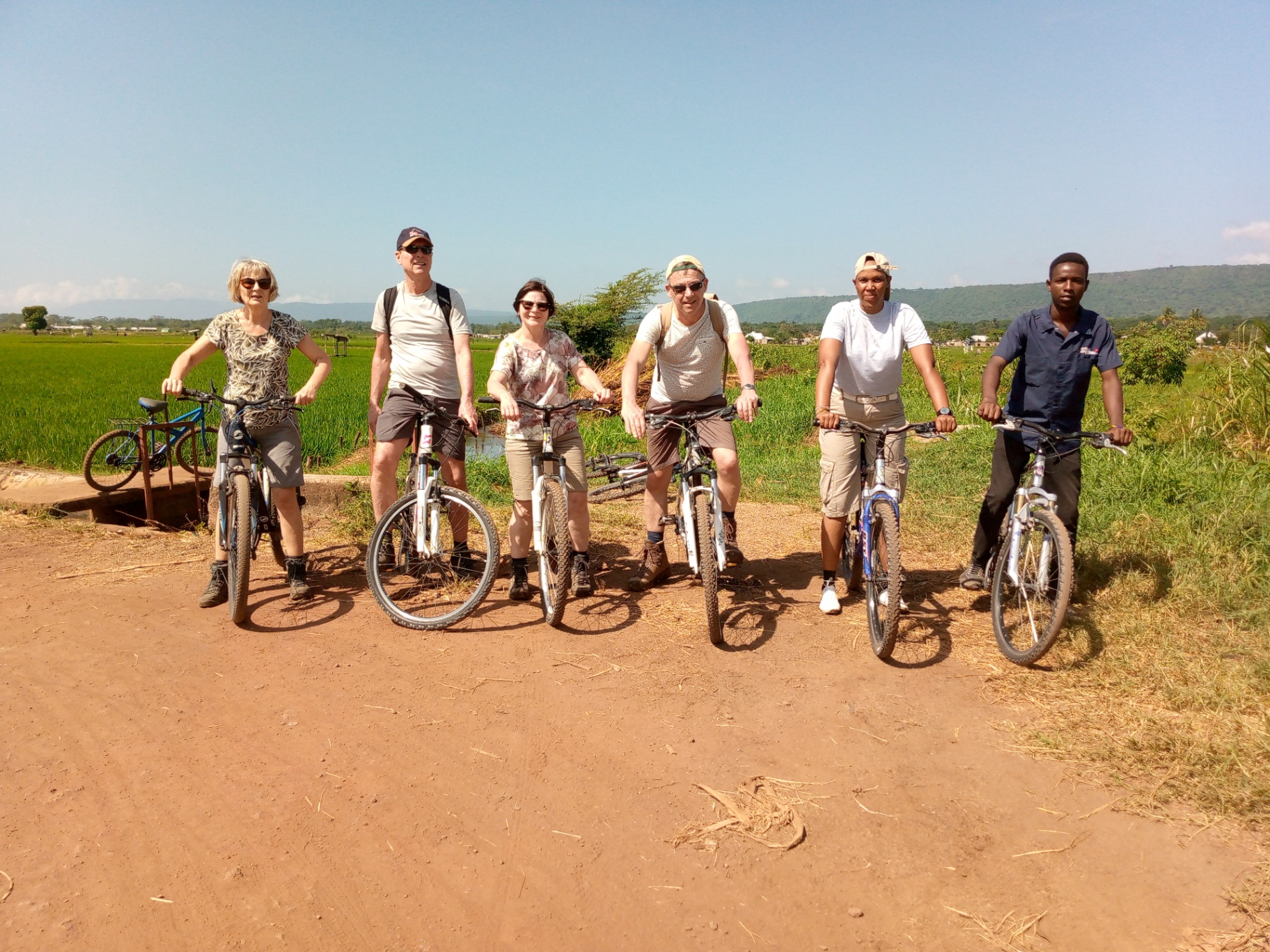 Group cycling tour through farmland to Lake Manyara