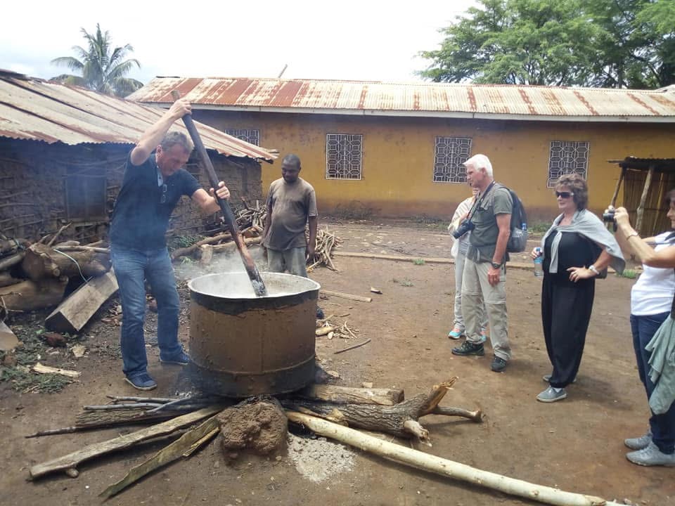 Visitors learning to cook traditional Tanzanian food over open fire