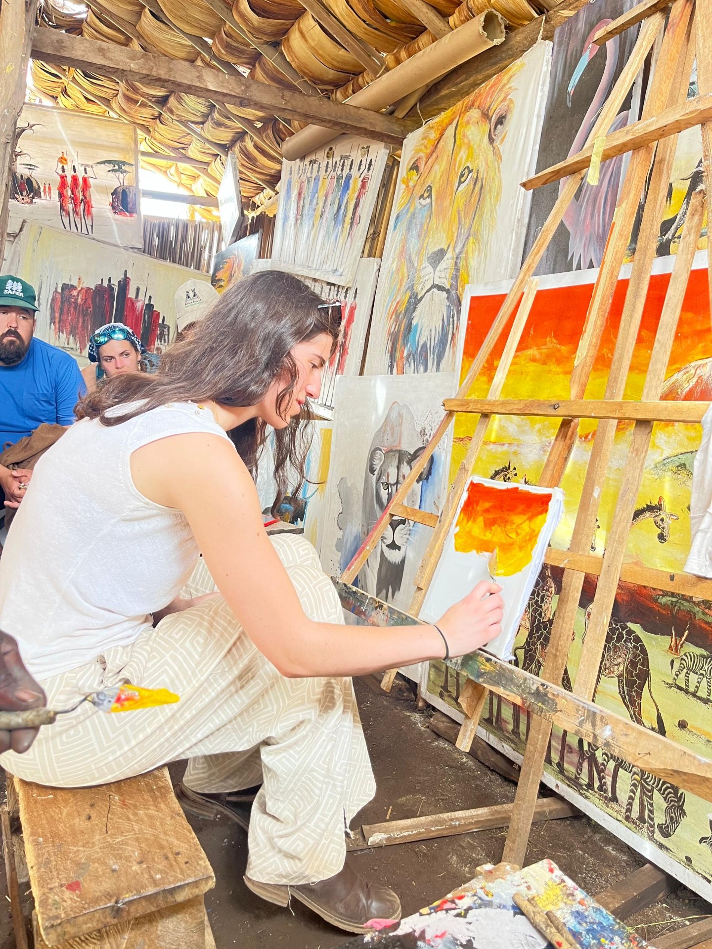 Visitor painting traditional African art in a local studio